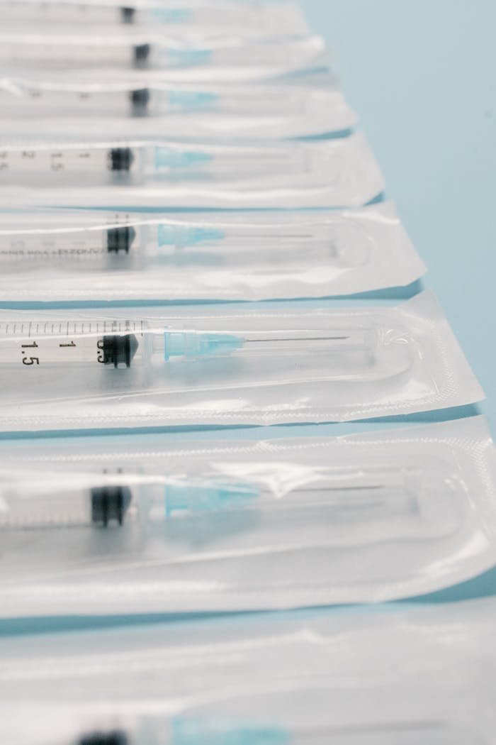 High-quality image of sterile packed syringes perfectly aligned on a blue background, highlighting medical preparedness.